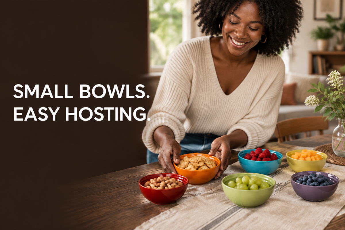 Black woman arranging snacks in six colorful bowls at a home dining table